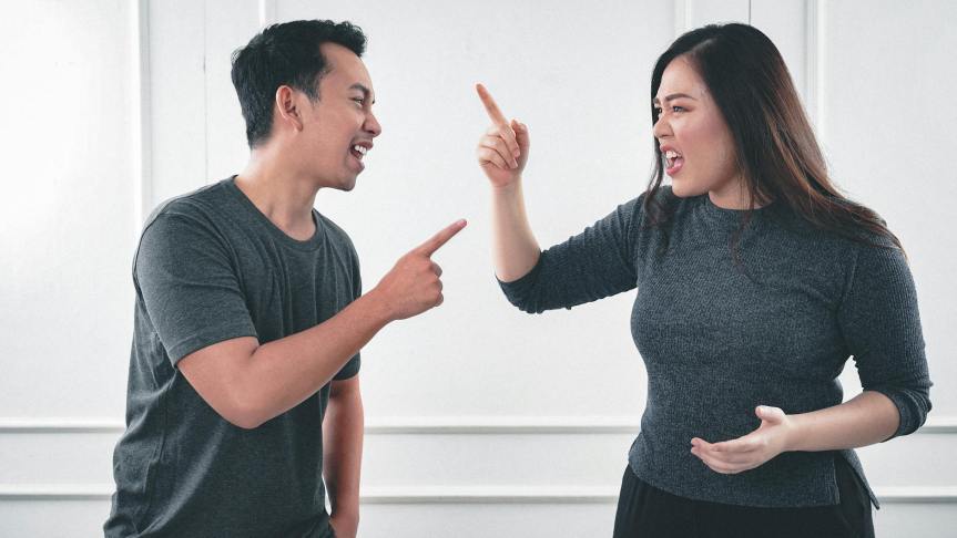 a man and woman arguing while pointing fingers